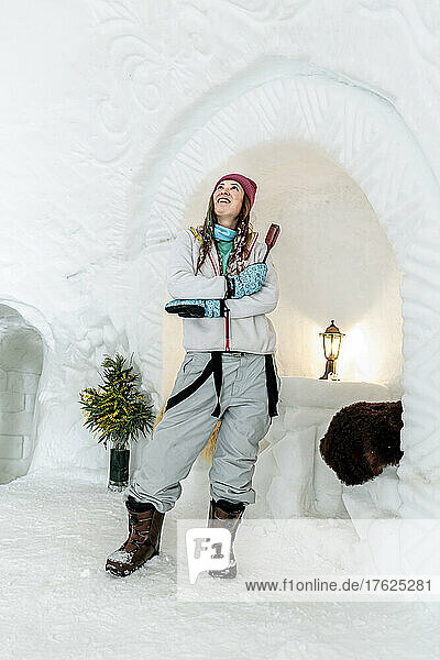 Smiling woman with carving tool standing in igloo