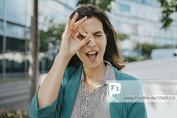 Happy businesswoman in smart casuals making ok gesture sign with hand