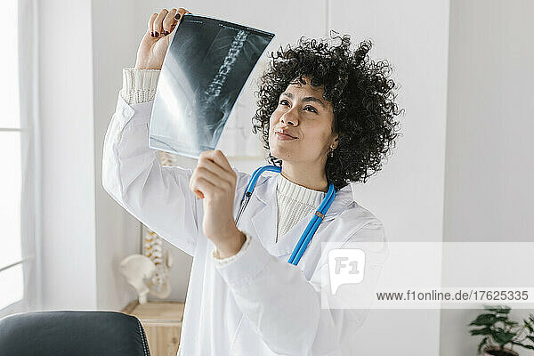 Doctor analyzing X-ray report at medical clinic