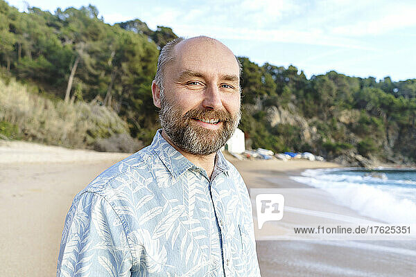 Smiling man with beard at beach