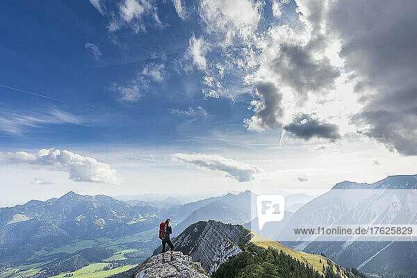 Female hiker admiring view from summit of Aiplspitz mountain