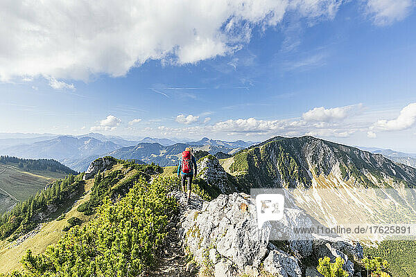 Female hiker walking along mountaintop of Aiplspitz