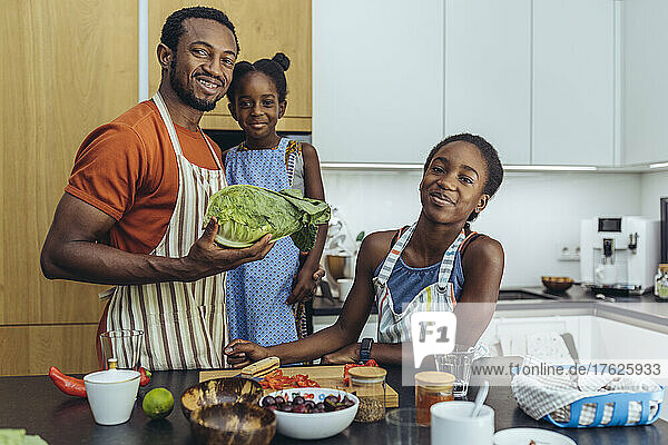 Smiling father with his daughters in kitchen at home