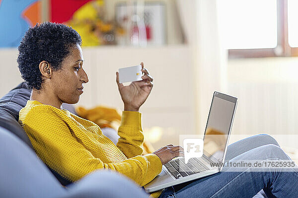 Woman with credit card doing online shopping on laptop at home
