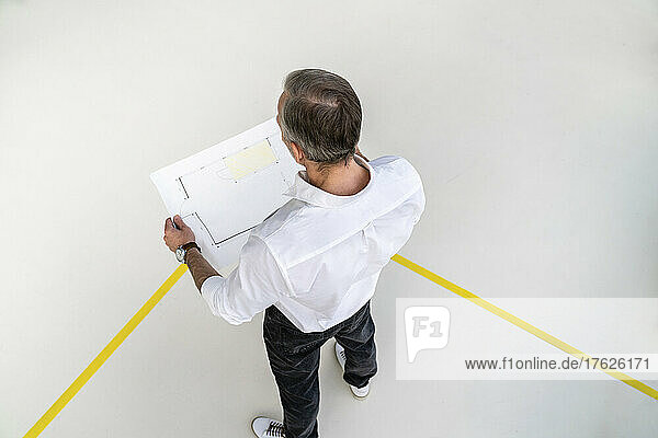 Businessman analyzing graph paper in office
