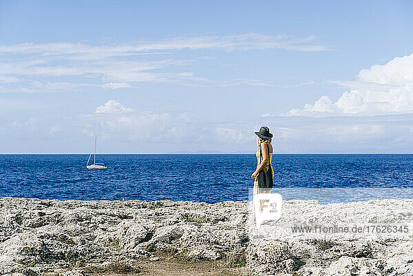 Tourist standing on rock looking at seascape  Minorca  Spain