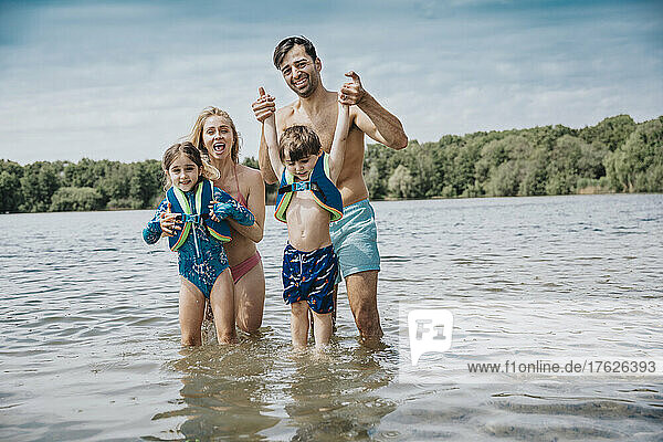 Happy family standing in lake on weekend