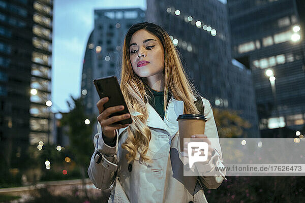 Beautiful woman using smart phone in city