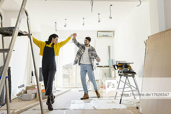 Glückliches Paar tanzt zu Hause im Wohnzimmer