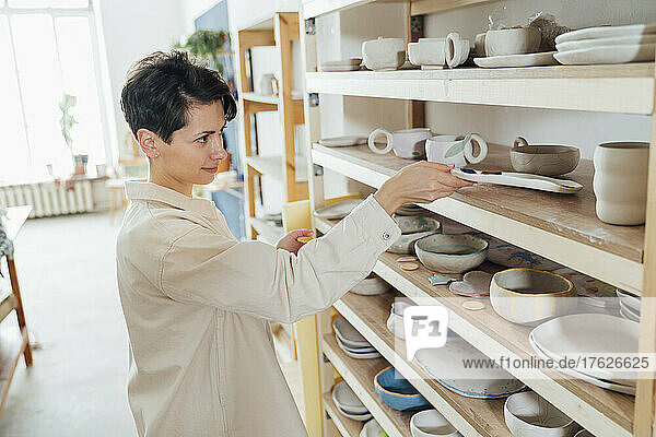 Besitzer untersucht Keramik in der Werkstatt