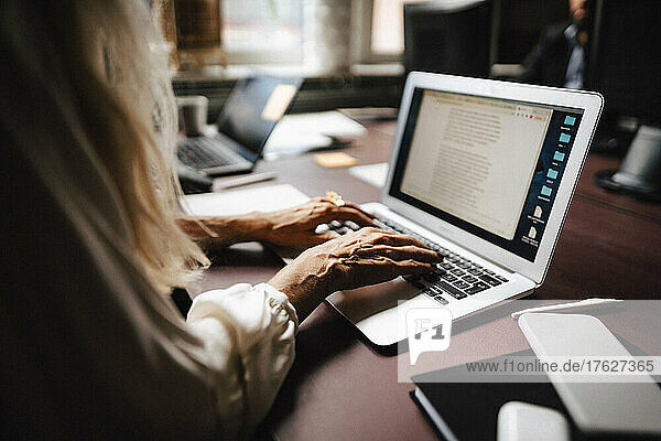 Midsection von weiblichen Anwalt mit Laptop während der Eingabe am Schreibtisch im Büro
