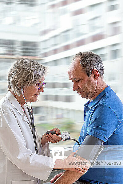 Doctor taking blood pressure from a senior.
