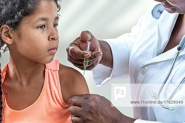 Little suspicious girl get an injection  vaccination