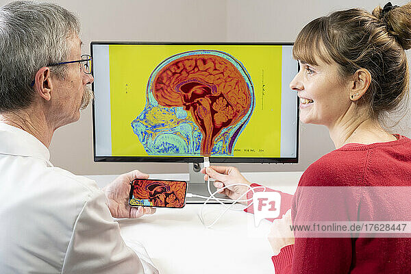 Researcher explaining to a woman how you can connect a smartphone to a brain.