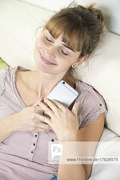 Woman worshiping her smartphone. Dependency and addiction behavior.