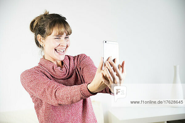 Extremely joyful woman at the sight of her new smartphone.