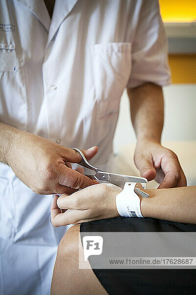 Nurse cutting off the identification bracelet before the patient is discharged.