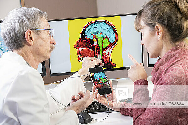 Researcher explaining to a woman how one will soon be able to plug his cell phone directly into the brain.