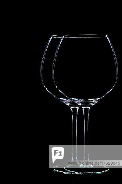 Style life of two wine glasses on black background.