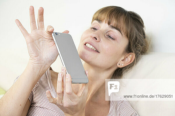 Woman worshiping her smartphone. Dependency and addiction behavior.