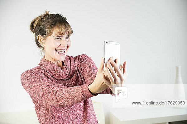 Extremely joyful woman at the sight of her new smartphone.