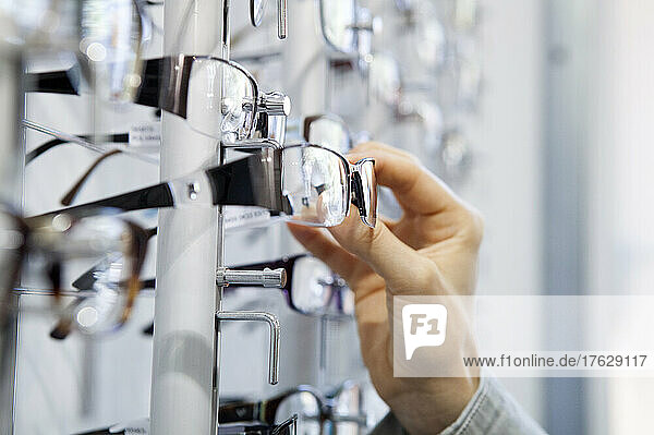 Woman choosing glasses at an optician.