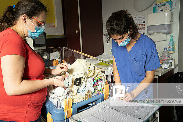 The mother and midwife caring for twins born prematurely.