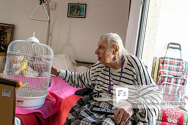 A hundred-year-old widow at the nursing home with her canary. Fifille is the name of the canary  locked up like her  but in a cage.
