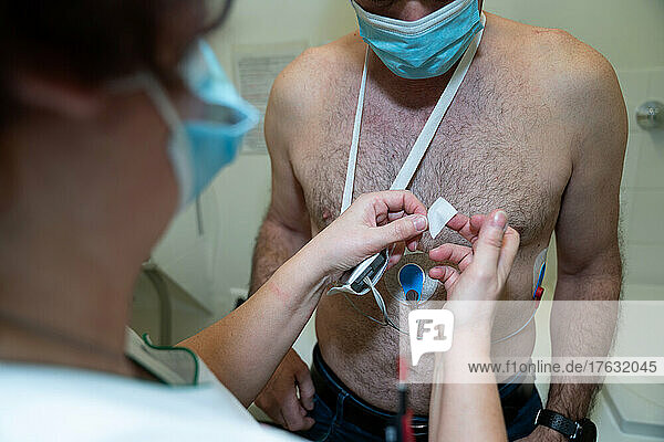 Placement of a holter on a fifty-year-old suffering from cardiac arrhythmia.