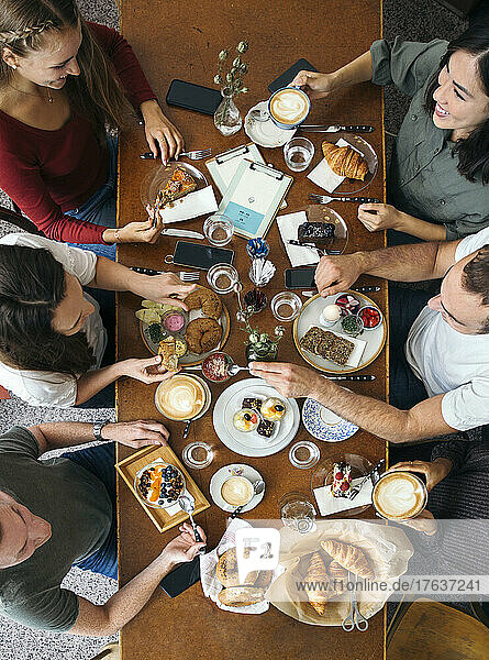 Overhead view of group of friends enjoying breakfast at restaurant table