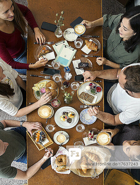 Overhead view of group of friends enjoying breakfast at restaurant table