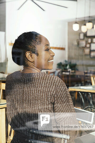 Smiling woman with digital tablet in cafe