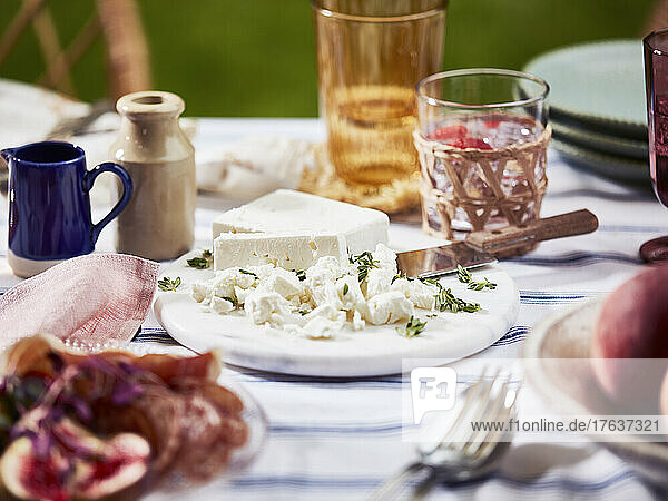 Feta cheese with thyme on plate on table