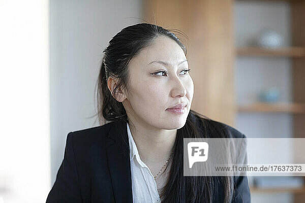Pensive businesswoman with documents in office