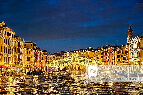 Famous Venetian tourist landmark Rialto bridge (Ponte di Rialto) over Grand Canal illuminated at night in Venice  Italy  Europe