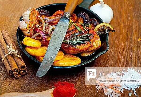 Roasted grilled BBQ chicken breast with herbs and spices rustic style on iron skillet