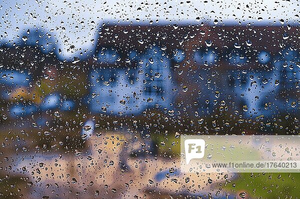 Regentropfen an einer Fensterscheibe von einem Mehrfamilienhaus bei starkem Gewitter  Hannover  Niedersachsen  Deutschland  Europa