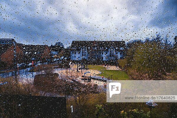 Regentropfen an einer Fensterscheibe von einem Mehrfamilienhaus bei starkem Gewitter  Hannover  Niedersachsen  Deutschland  Europa