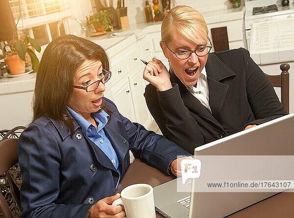Geschäftsfrauen feiern ihren Erfolg auf dem Laptop in der Küche