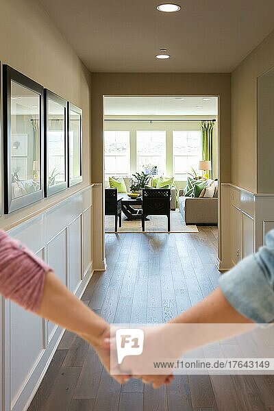 Couple holding his hands and walking through hallway of a new house