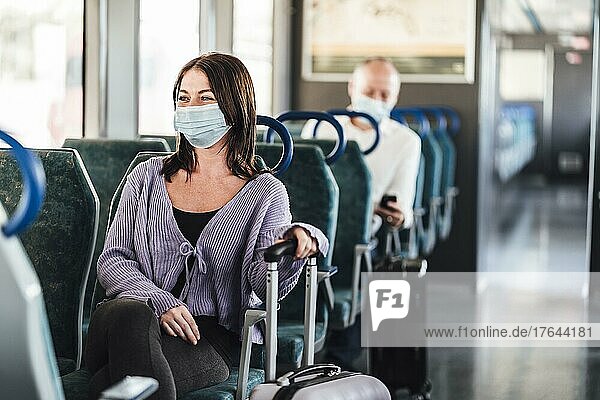 Positive commuters wearing mask enjoying their train trip