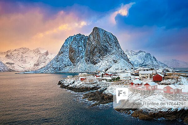 Famous tourist attraction Hamnoy fishing village on Lofoten Islands  Norway with red rorbu houses. With falling snow in winter on sunrise