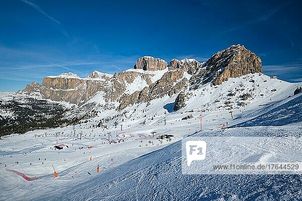 View of a ski resort piste with people skiing in Dolomites in Italy. Ski area Belvedere. Canazei  Italy
