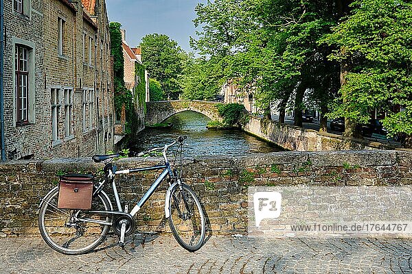 Typical Belgian scenic cityscape Europe tourism and bicycle transport concept  bicycle on a bridge near canal and old house. Bruges (Brugge)  Belgium