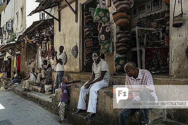 Läden  Menschen sitzen auf Stufen  Gasse  Stone Town  UNESCO Weltkulturerbe  Unguja  Sansibar  Tansania  Afrika