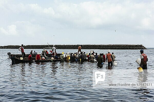 Fischer und Fischhändler im Wasser am Fischereihafen  kleines Fischerboot  Stone Town  Unguja  Sansibar  Tansania