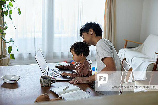 Japanese man working from home with kid