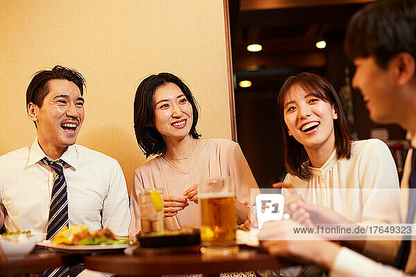 Japanese businesspeople having drinks and dining at a bar
