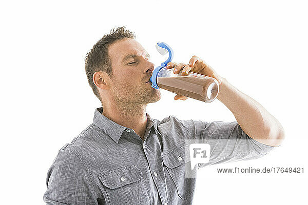 Studio shot of man drinking protein shake