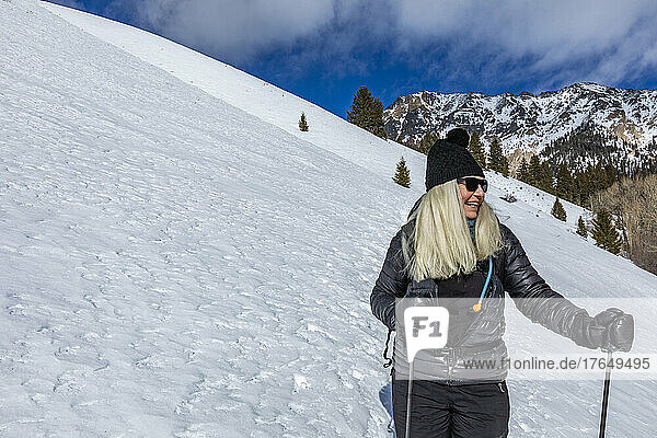 United States  Idaho  Ketchum  Smiling senior woman snowshoeing near Sun Valley on sunny winter day